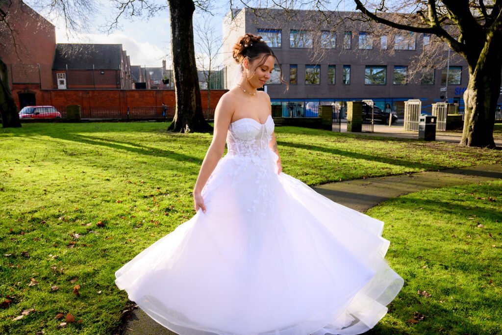 Bride in a white gown posing in front of urban architecture in West Bromwich.
